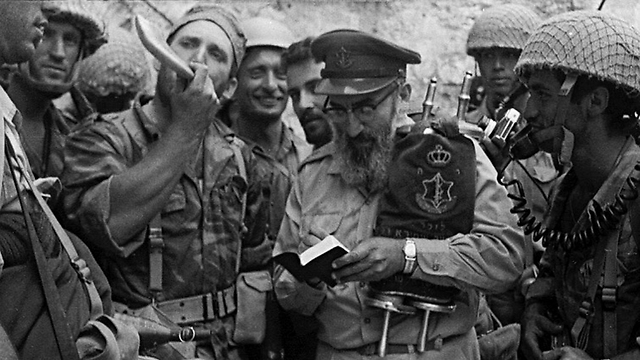 In this 1967 photo, Rabbi Shlomo Goren carries the Torah scroll as he holds the first Jewish prayer session at the Western Wall since 1948 (Reproduction photo: Benny Ron)