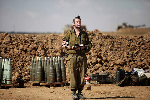 An IDF reservist praying during Operation Protective Edge. (Photo: EPA)