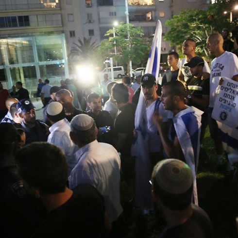A Breaking the Silence protest and a counter-demonstration face off during Operation Protective Edge. (Photo: Moti Kimchi)