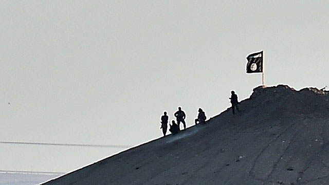 IS militants place flag atop hill in Kobani (Photo: AFP)