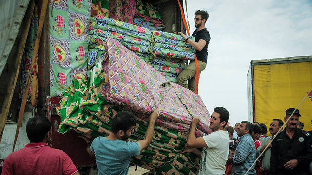 Israeli aid workers distributing mattresses to Yazidi and Christian refugees who escaped Kobani (Photo: IsraAID) 