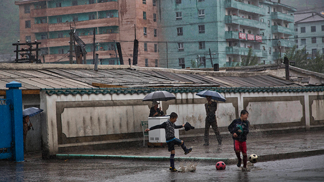 כדורגל ומטריות בגשם שוטף בהייסאן (צילום: AP)