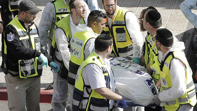 Removing a body from the scene of the attack. (Photo: AFP)