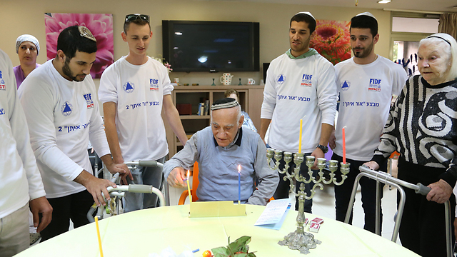 Released IDF soldiers light first candle of Hanukkah at the Gil Oz retirement home in Petah Tikva. (Photo: Yaron Brenner)