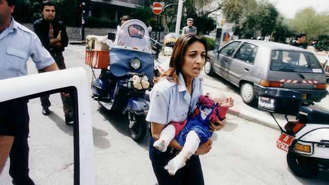 The photo that moved an entire nation - policewoman Ziona Bushri carrying baby Shani after the bombing (Photo: Michael Kremer)