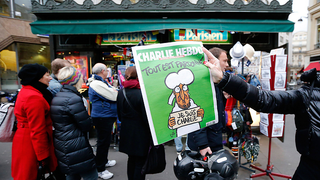 Cover displayed as crowd lines up to purchase issue in Paris earlier in January (Photo: Reuters)
