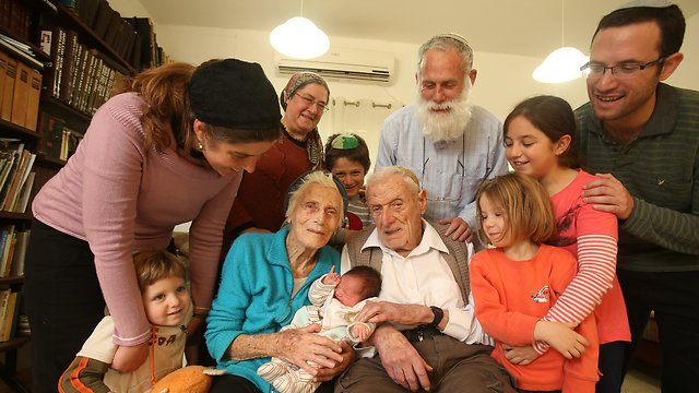 Michael and Marion Mittwochs, center, surrounded by family and holding their 100th great-granchild. (Photo: Elad Gershgoren)