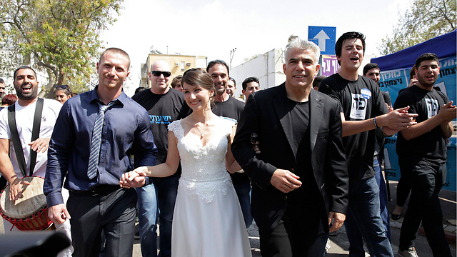 Yair Lapid catches up with the bride and her new spouse in Holon. (Photo: Reuters)