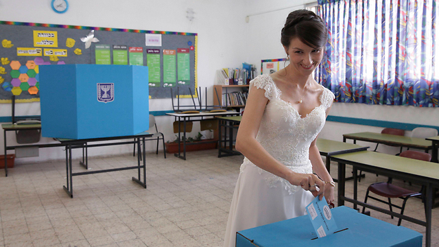 A bride votes in her wedding dress in Holon (Photo: Reuters)