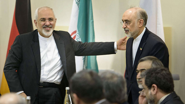 Iranian Foreign Minister Zarif greets Ali Akbar Salehi, head of Atomic Energy Organization (Photo: AFP)