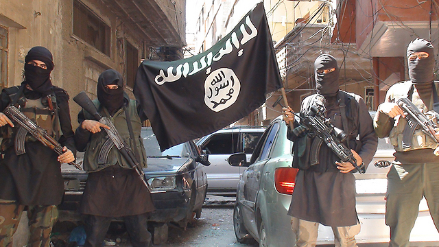 Islamic State members wave their flag in the Yarmouk camp. 