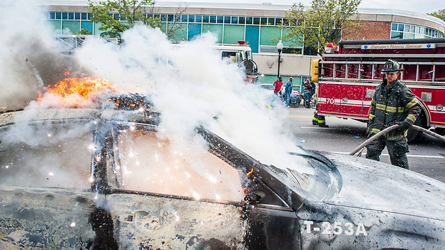 Firefighters extinguish burning car (Photo: EPA)
