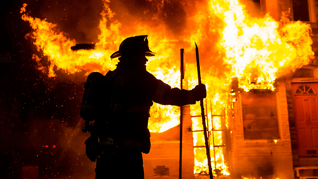 Firefighter near burning home (Photo: Reuters)