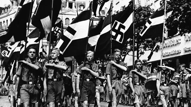 In this Feb. 24, 1936 file photo, a group of boys march beneath Nazi standards in Berlin (Photo: AP)