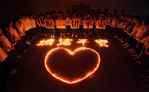 Praying for the victims of the Tianjin explosion in China. (Photo: AFP)
