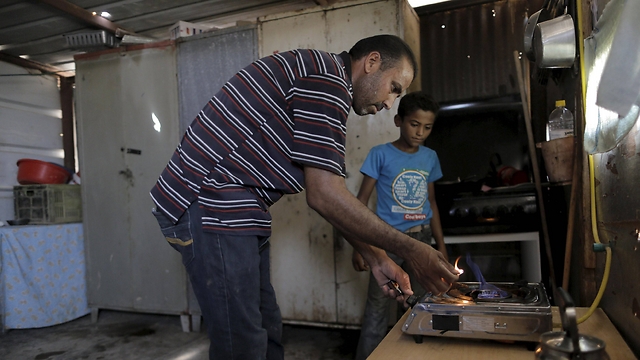 Nayef Zayed lights a gas burner running on methane produced in a HomeBioGas digester (Photo: Ammar Awad, Reuters)