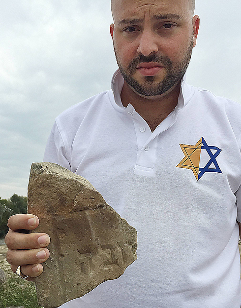 Jonny Daniels, the head of Jewish foundation 'From the Depths' displays tombstone fragment (Photo: AP)