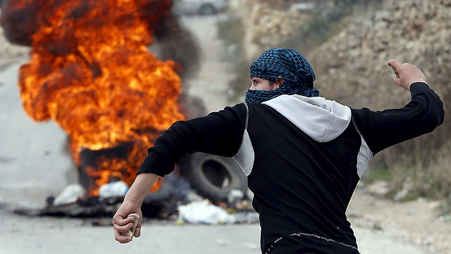 A Palestinian about to throw a stone in Hebron. (Photo: Reuters)