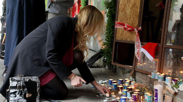 People placing candles at the scene of the shooting in Tel Aviv that killed two people (Photo: Inbal Halamish)