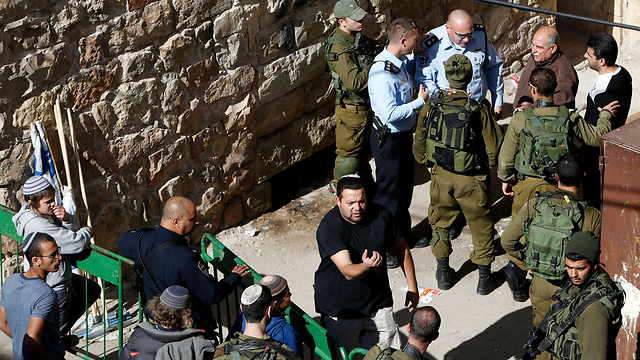 IDF troops evicting the settlers from the two houses in Hebron, the morning after they moved in (Photo: Reuters)