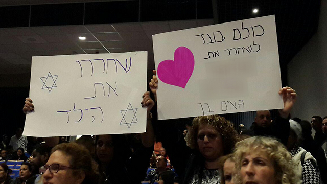 Supporters holding signs in the courtroom (Photo: Shachar Hai)