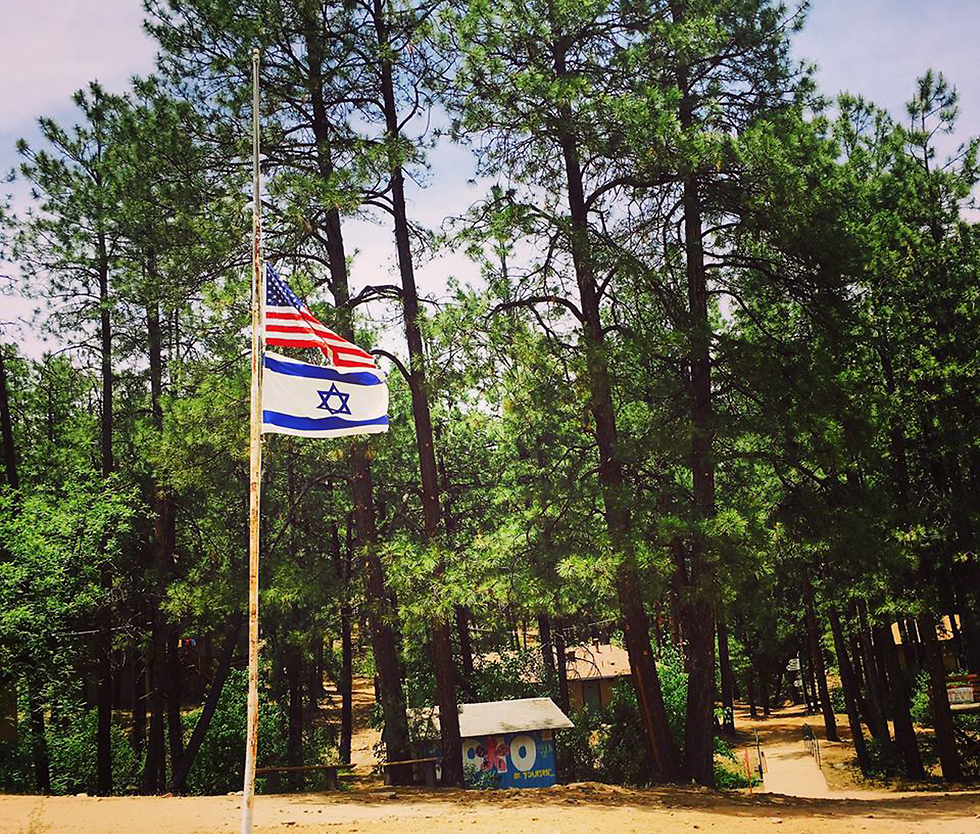 US and Israeli flags at half-staff at the girl's summer camp