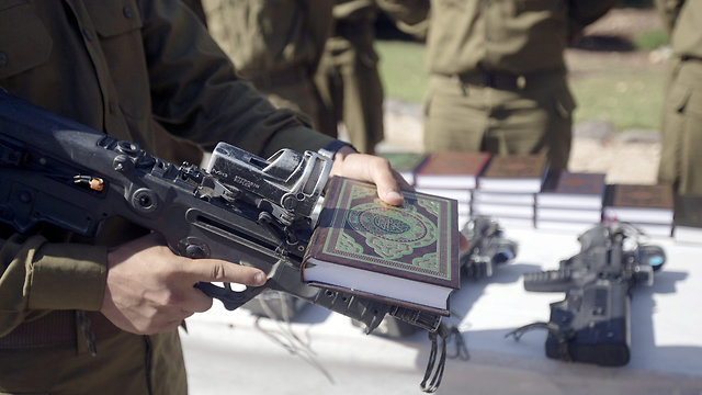 Two IDF supplies: rifle and Koran (Photo: EPA)