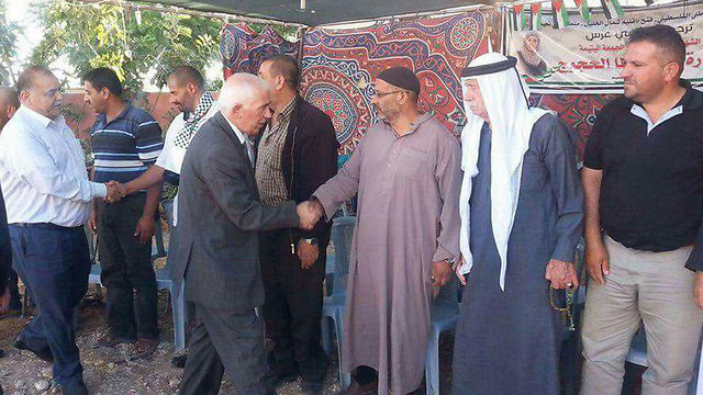 Kamal Hamid shaking the hands of mourners