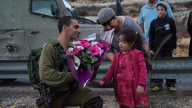 Tahel presents a bouquet to the soldiers (Photo: IDF Spokesperson)