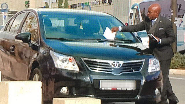 Representante da Embaixada Angolana com um bilhete de estacionamento (Foto: Canal 1)