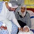 התינוקת טרא אבו חוסיין עם אביה ואמה