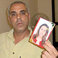 Rafat Haj Yihyeh holding his wife's photo  