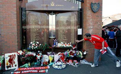אוהד ליברפול מניח זר על אתר הנצחה לקורבנות אסון הילסבורו (צילום: AP) (צילום: AP)