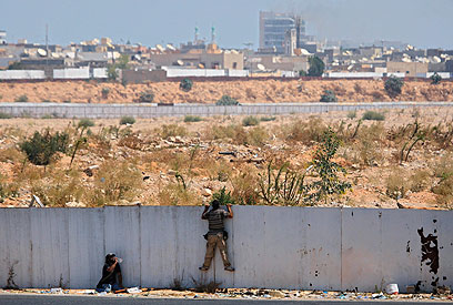 לוחמי המורדים משקיפים על מתחם קדאפי (צילום: AP) (צילום: AP)