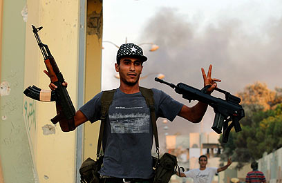מי יאסוף מהם את הנשק? מורד לובי במתחם מגורי קדאפי בטריפולי (צילום: רויטרס) (צילום: רויטרס)