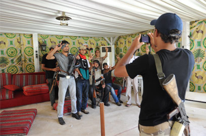 מורדים מצטלמים במאהל של קדאפי האב בבאב אל-עזיזיה (צילום: MCT) (צילום: MCT)