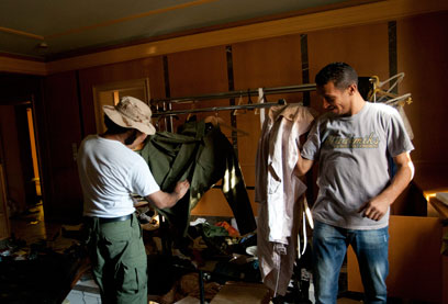 בוזזים מודדים בגדים בבית עיישה. הניחו לנברשות הקריסטל (צילום: AP) (צילום: AP)