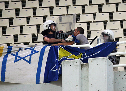 אוהדים יוונים מנסים להוריד את דגלי ישראל באצטדיון באתונה (צילום: EPA) (צילום: EPA)
