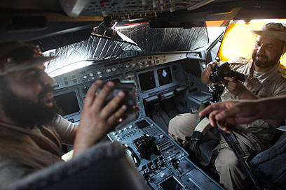 הנוסע קדאפי מתבקש להדק חגורות. המורדים בתא הטייס (צילום: AP) (צילום: AP)