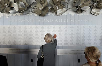 ואלה שמות. אשה מחפשת שמו של בנה בלוח הזיכרון לקורבנות התאומים  (צילום: AP) (צילום: AP)