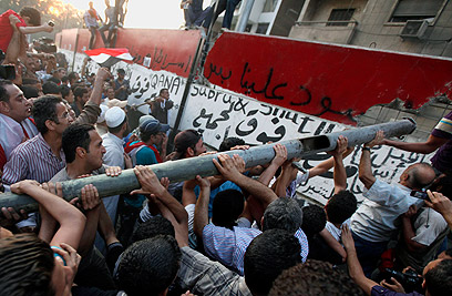 Egyptians demolishing wall outside embassy (Photo: Reuters)