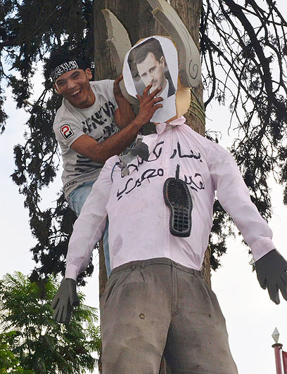 מפגין בטריפולי תולה בובה של הנשיא אסד (צילום: AP) (צילום: AP)