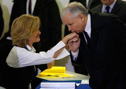 קצ'ינסקי מנשק את ידה של משגיחת בחירות לפני הצבעתו (צילום: רויטרס) (צילום: רויטרס)