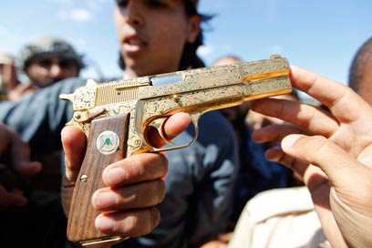 המורדים מציגים אקדח מוזהב, שהיה שייך לטענתם לקדאפי (צילום: רויטרס) (צילום: רויטרס)