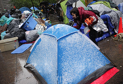 מתנדבת מציעה טיפול רפואי ליושבי האוהלים המושלגים (צילום: AFP) (צילום: AFP)