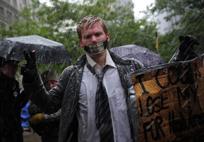 מפגין בגשם ובשלג בניו יורק. "עלול לאבד את משרתי כי יש לי קול" (צילום: AFP) (צילום: AFP)