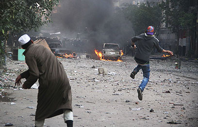 קהיר בלהבות. מפגינים מיידים אבנים על כוחות הביטחון (צילום: AP) (צילום: AP)
