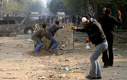 רוססו בגז מדמיע והשיבו ביידוי אבנים. מפגינים בקהיר (צילום: AP) (צילום: AP)