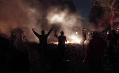 המפגינים על רקע הגז המדמיע (צילום: AFP) (צילום: AFP)