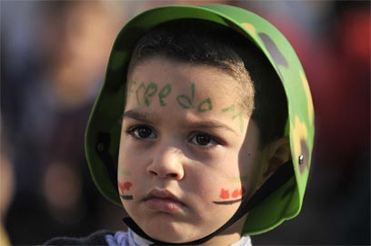 ילד סורי גולה מפגין נגד אסד ביוון. "המדינה לא שייכת לי" (צילום: AFP) (צילום: AFP)